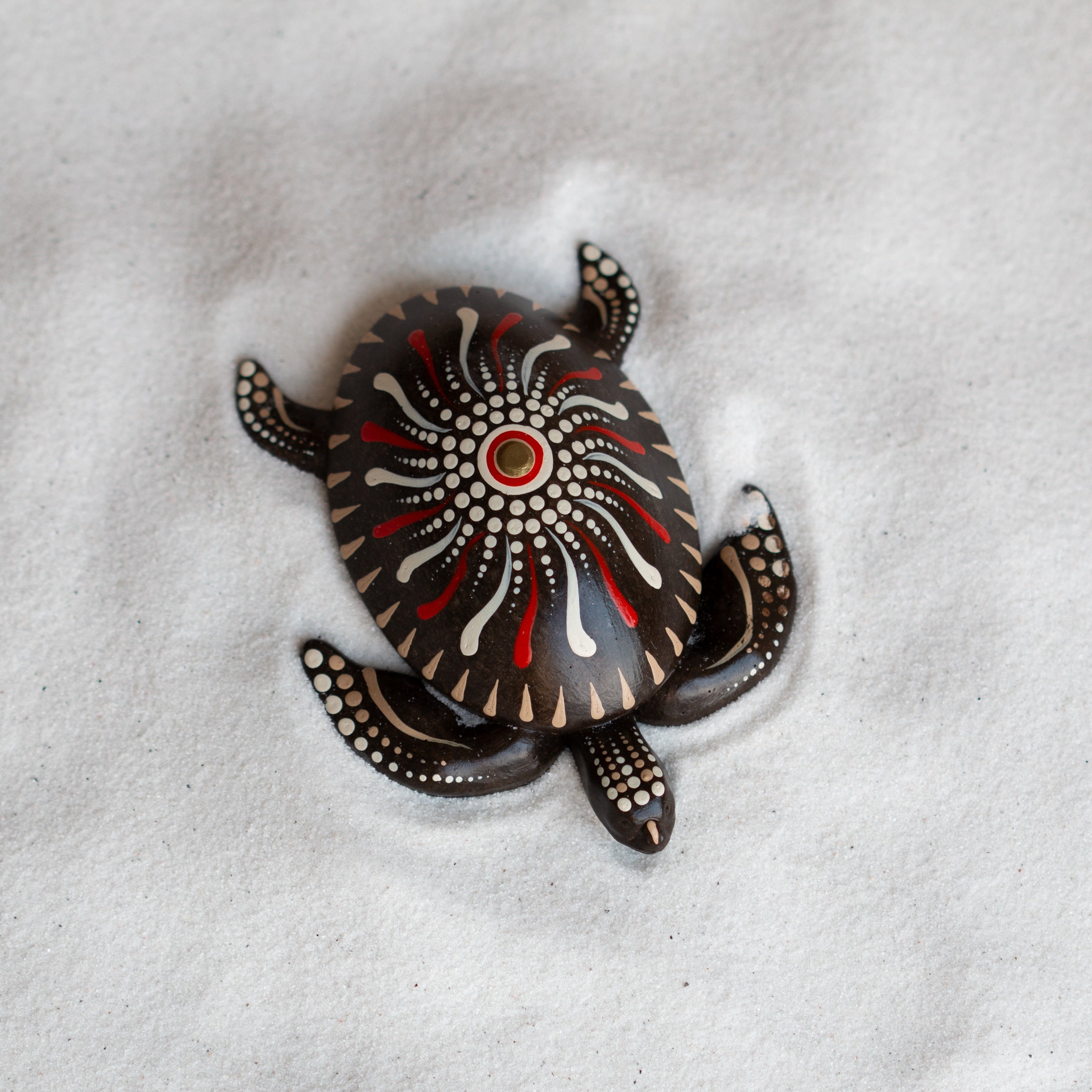 Decorative turtle-shaped object on sand  Petit Joys artisanal goods 